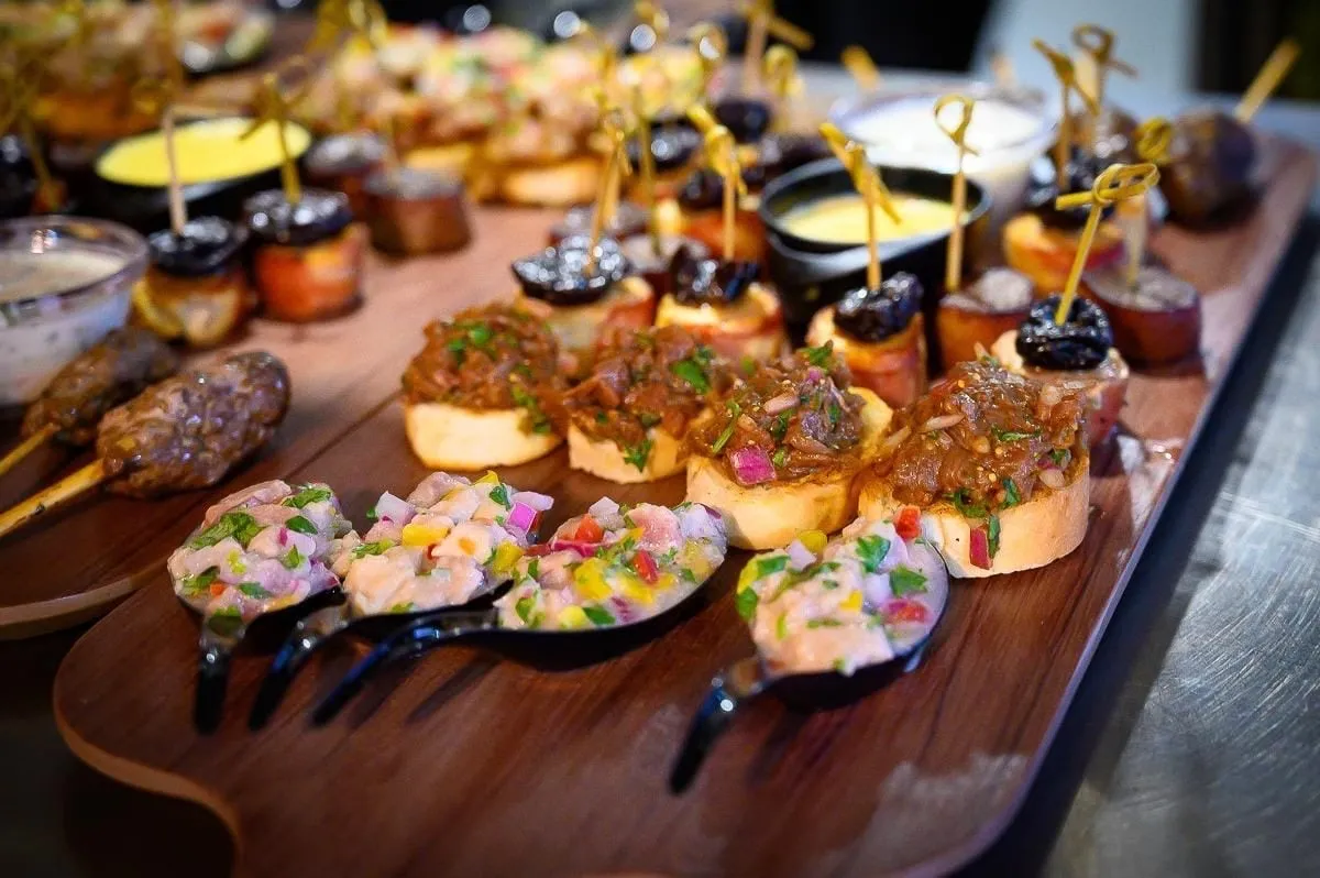Tabla de canapés de La Miga, con tartares y ceviches servidos en cucharas y tostadas