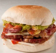 Sánguche de La Miga en primer plano, con tocino, palta y tomate